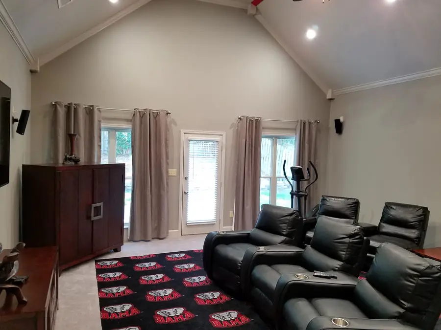 Theater room addition with tiered leather recliners and an Alabama rug
