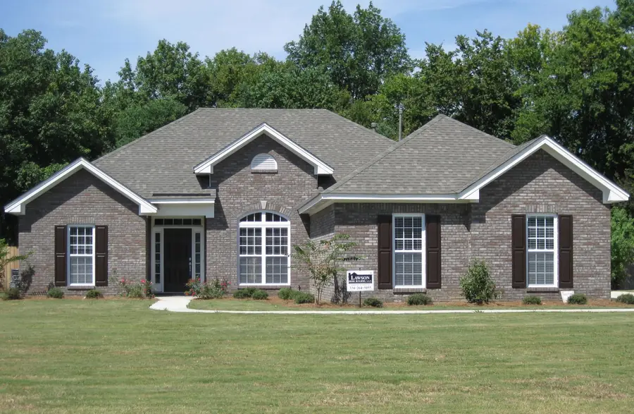 Dark brick home with twin gables, arched windows and black shutters