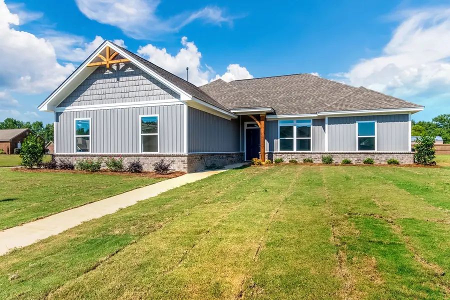 Blue-gray board-and-batten home with a stained timber gable bracket in Deatsville, Alabama