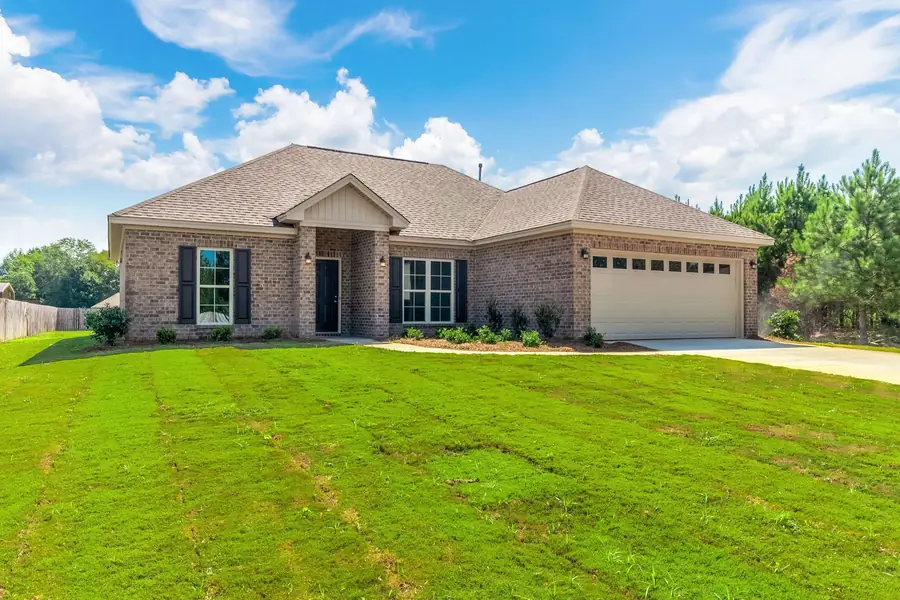 Brick home with black shutters and a two-car garage on a new lawn in Deatsville, Alabama