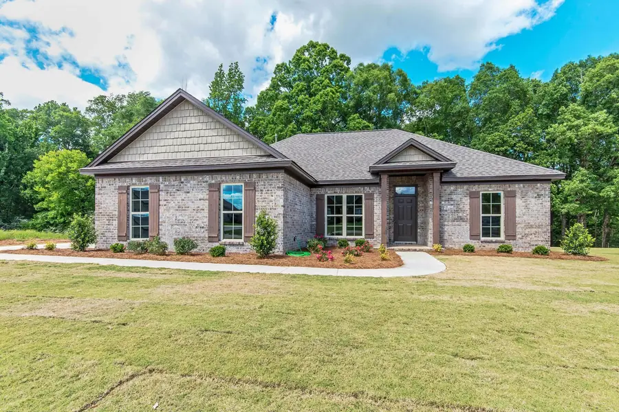Gray brick home with a shake-shingle gable and arched front entry in Deatsville, Alabama