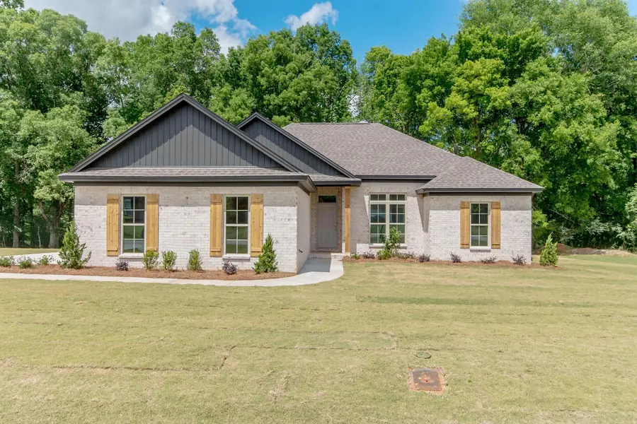 Painted white brick home with dark board-and-batten gables and cedar shutters in Deatsville, Alabama